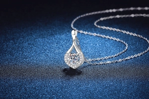 Macro detail of S925 sterling silver teardrop pendant with 1ct moissanite on starry background