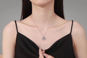 Detail view of S925 sterling silver four-leaf clover pendant necklace worn by a model