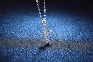 Macro shot of 925 silver cross pendant with 6 brilliant round-cut moissanite stones