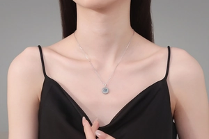 Gros plan du collier avec pendentif moissanite ronde de 1 carat porté au cou d'une femme