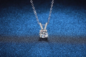 Detail of four-prong moissanite pendant with V-shaped pavé bail on S925 silver chain