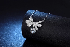 Detailed macro shot of a sparkling bow pendant with a 2-carat round cut moissanite gemstone