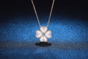 Détail du pendentif trèfle S925 avec nacre blanche et moissanite centrale sur chaîne dorée