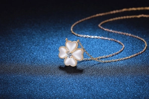 Détail du collier trèfle à quatre feuilles doré avec pendentif en nacre blanche