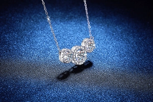Close-up of S925 silver necklace with three round-cut moissanite stones in halo setting