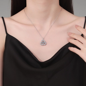S925 sterling silver necklace with sparkling blue gemstone floral pendant on a model