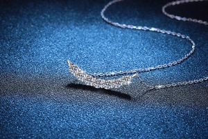 Macro shot of 1.4 carat Moissanite smiley curved pendant necklace in S925 silver
