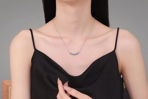 Close-up of S925 silver necklace with blue moissanite smile pendant worn by a model