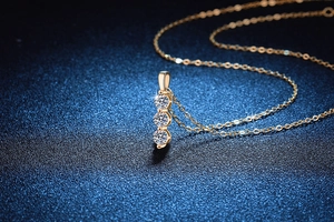 Close-up of gold S925 silver necklace featuring three vertical Moissanite diamonds
