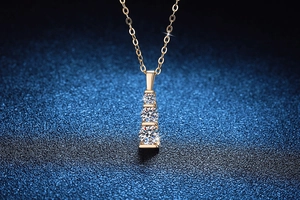 Macro shot of 925 sterling silver gold necklace with three graduated moissanite pendants