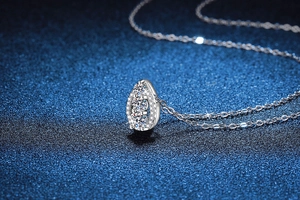 Macro detail of 925 silver necklace featuring a sparkling teardrop moissanite pendant