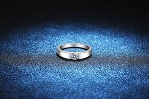 Detailed close-up of a minimalist silver S925 moissanite solitaire ring with a round diamond