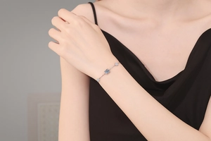 Detail of s925 silver bracelet with square blue gemstone on woman's wrist