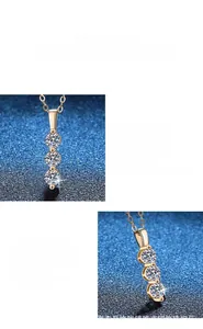 Close-up of three-stone vertical moissanite pendant in rose gold finish showing fine detail