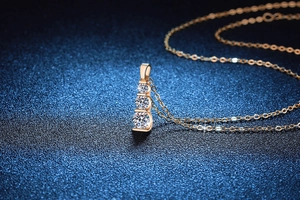 Macro shot of rose gold 925 sterling silver necklace with three round moissanite stones