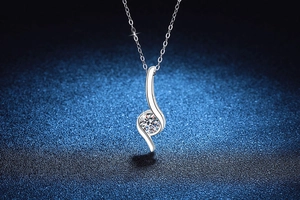 Close-up of S925 sterling silver necklace with moissanite pendant on blue texture