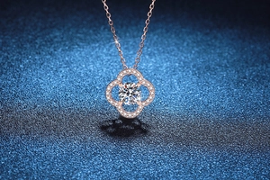 Macro shot of rose gold four-leaf clover pendant with sparkling moissanite stone