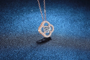 Detail showing rose gold four-leaf clover pendant with moissanite and micro-pave setting