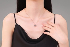 Close-up of rose gold clover pendant necklace with sparkling stone on model