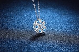 Macro shot of S925 silver snowflake necklace with a dancing moissanite and blue gems
