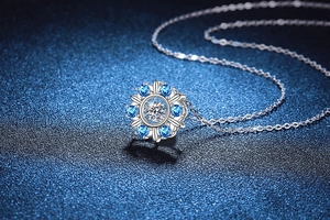 Detailed close-up of S925 silver sunflower pendant with blue gemstones and moissanite