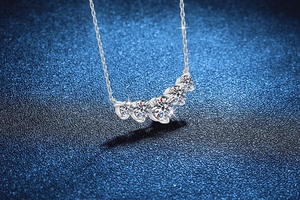 Detail of five-stone curved moissanite necklace in S925 sterling silver on starry background