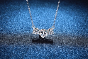 Macro shot of three-stone Moissanite pendant with 925 sterling silver prong setting