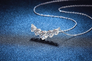 Macro shot of silver S925 necklace with five-stone curved moissanite pendant