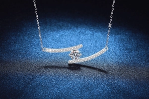 Macro detail of 925 silver necklace with 1ct moissanite in a cross curve pendant
