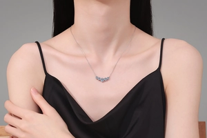 Close-up of S925 sterling silver necklace featuring seven blue gemstones on a female model