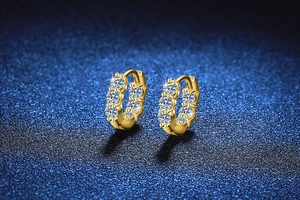 Close-up of gold-plated hoop earrings featuring a row of sparkling moissanite stones