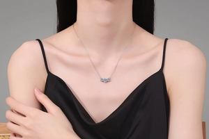 Close-up of S925 sterling silver necklace with three round-cut moissanite stones on model
