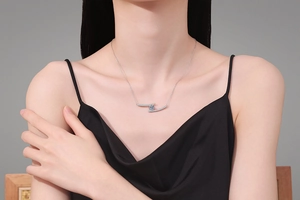 Model wearing 925 silver necklace with blue moissanite pendant and pavé set curved bars