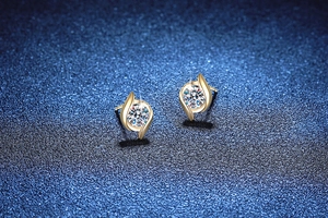 Macro detail of S925 silver 1ct Moissanite earrings with golden leaf swirl design