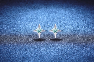 Detail view of S925 silver four-pointed star earrings with light blue moissanite stones