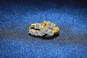 Macro shot of gold S925 silver hoop earrings with five sparkling moissanite stones