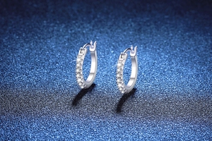 Macro detail of S925 sterling silver hoop earrings with shimmering moissanite inlay