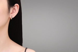 Detail of 925 silver gold-plated hoop earrings with light blue moissanite stones