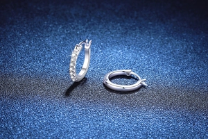 Macro detail of S925 sterling silver hoop earrings with sparkling moissanite stones
