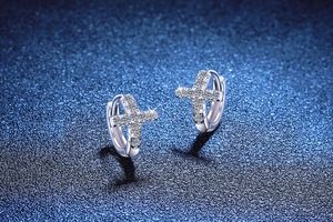 Macro detail of S925 sterling silver cross earrings featuring sparkling moissanite stones