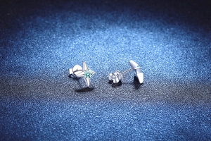 Macro shot of S925 silver four-pointed star stud earrings with blue moissanite gemstone