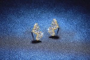 Dettaglio macro di orecchini a lobo in argento S925 dorato con cluster di moissanite