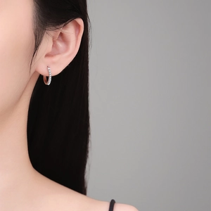 Elegant S925 sterling silver hoop earrings with micro-pave moissanite stones on a model