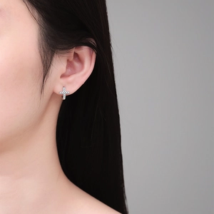 Elegant S925 sterling silver cross hoop earrings with moissanite stones on a model