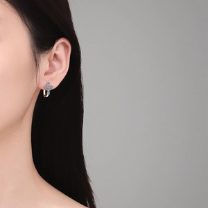 Boucles d'oreilles croix en argent 925 avec moissanite bleue portées par modèle