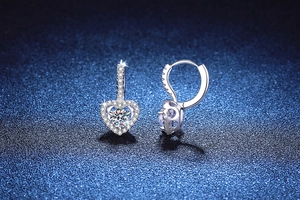 Macro view of heart shaped S925 sterling silver earrings with dancing moissanite stones