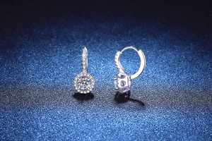 Détail de boucles d'oreilles halo en argent avec moissanite 1 carat et pavé de diamants