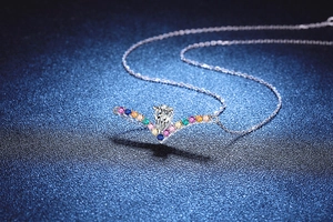 Macro detail of V-shaped S925 silver pendant with 1ct pear-cut moissanite and colorful gems