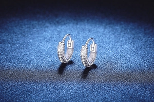 Macro shot of silver S925 huggie earrings with triple row pave moissanite detail