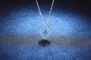 Vue macro du pendentif goutte d'eau avec moissanite bleue dansante en argent S925